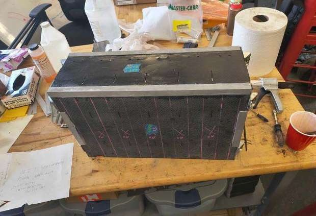 Closed carbon battery enclosure with aluminum edges