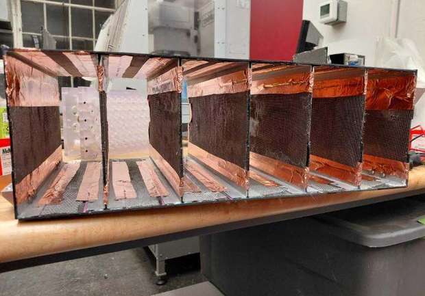 Open composite battery box with internal walls lined with copper foil