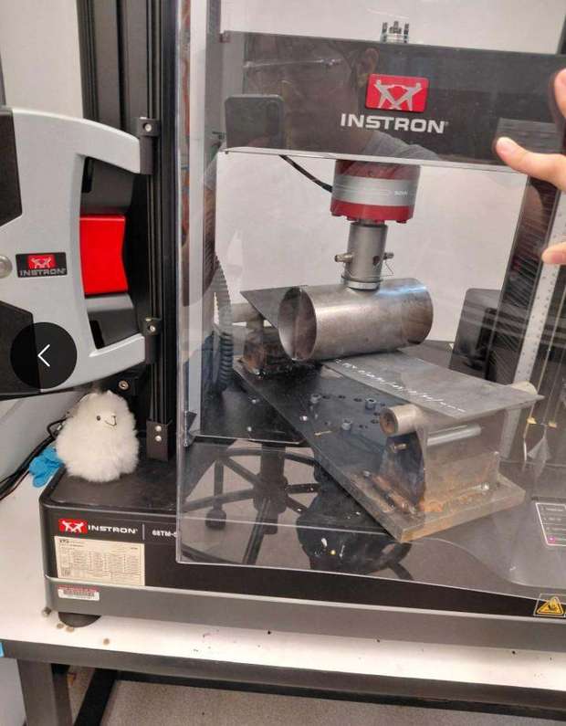 Metal tube being crushed in an Instron